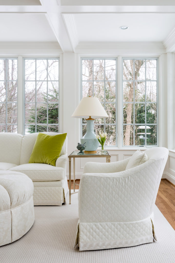 Potomac, MD white living room with snow outside with interior design by Anthony Wilder