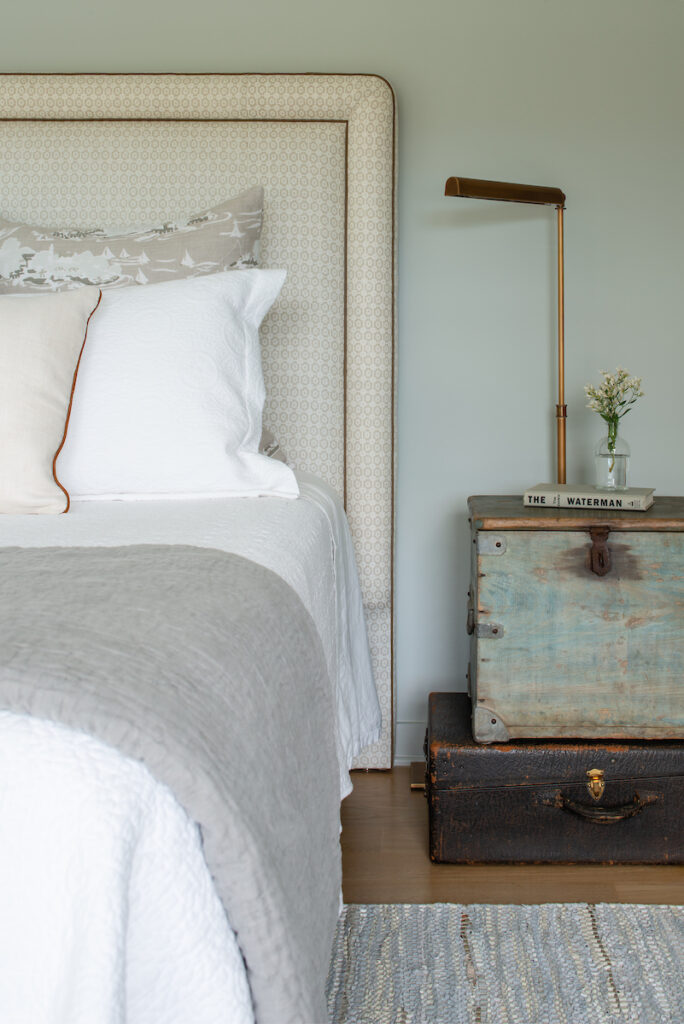 Cozy bedroom with an upholstered neutral headboard and a custom bedside table