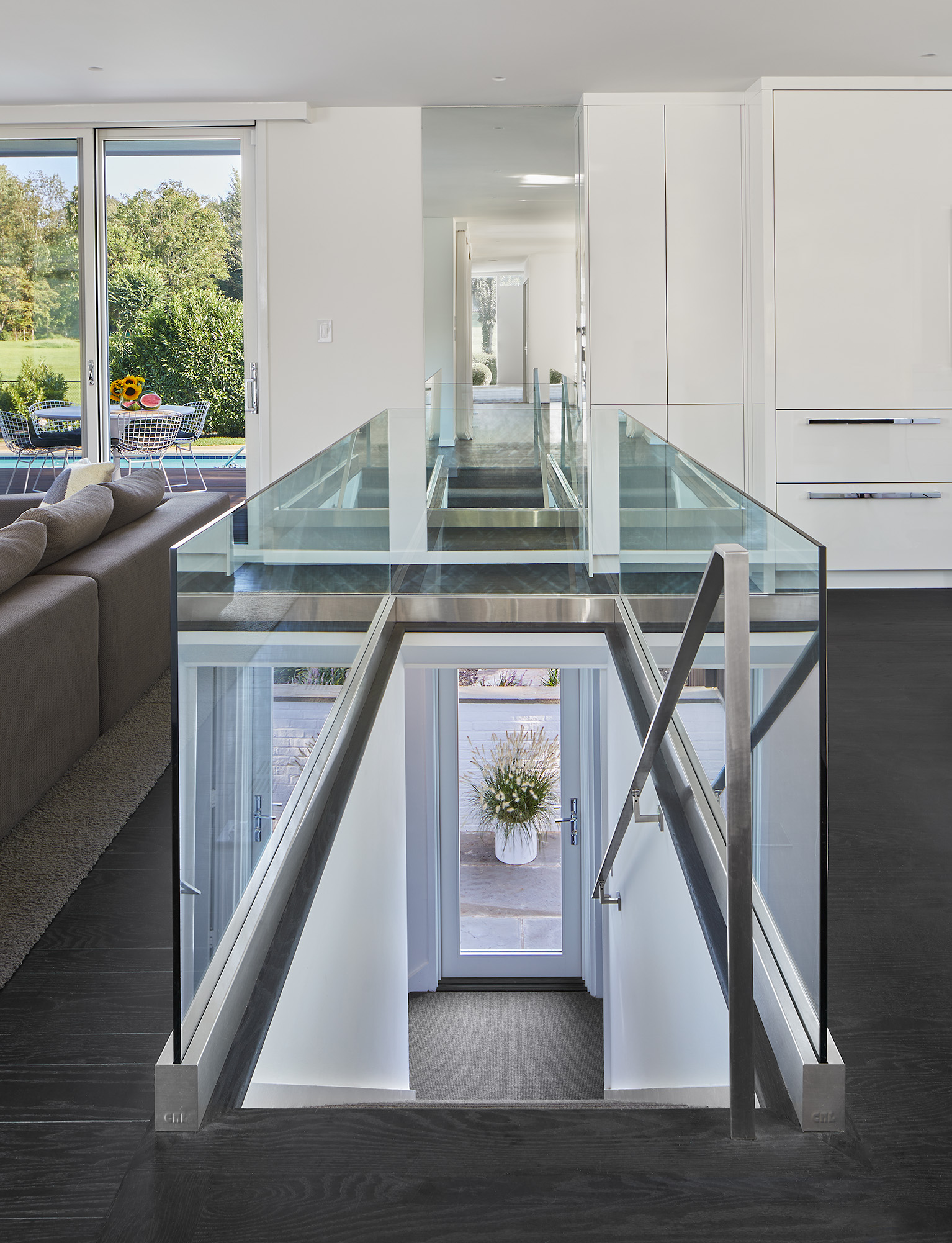 Modern front staircase with stainless-steel railings surrounded by glass