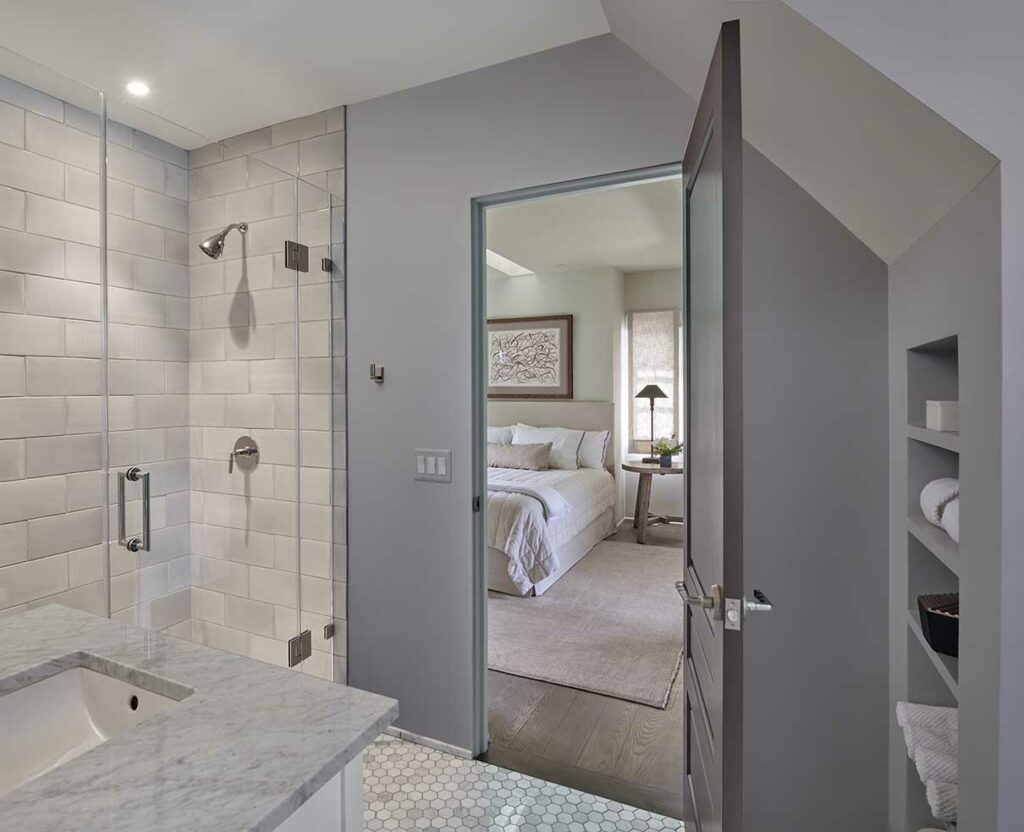 primary suite renovation in bethesda maryland including an ensuite bathroom with a glass shower enclosure featuring pale gray oversize offset subway tile