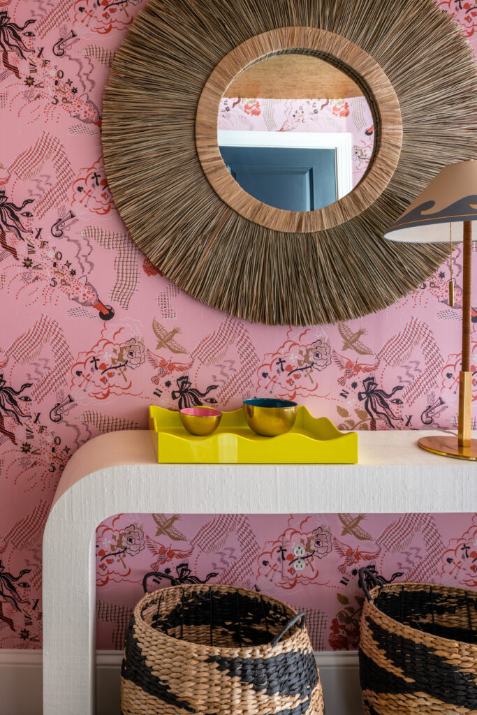 Interior design including pink nature inspired wallpaper and gold mirror