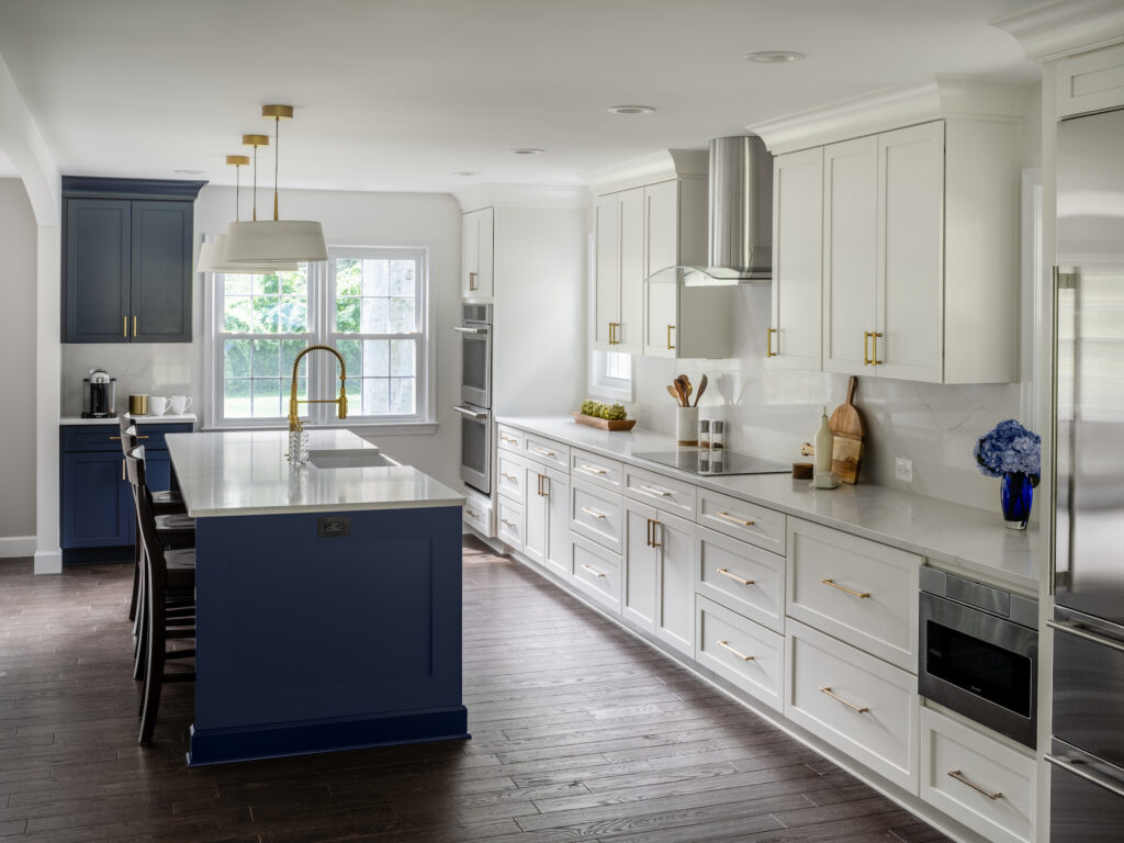 Kitchen renovation to open up the space with a dark blue based island with white quartz countertops